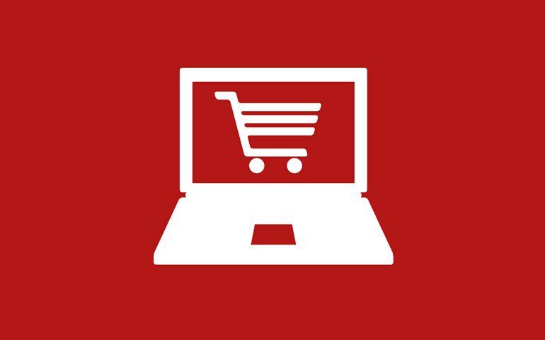 Ein weißer Laptop mit einem Einkaufswagen-Symbol auf dem Bildschirm vor einem roten Hintergrund repräsentiert einen Webshop.
